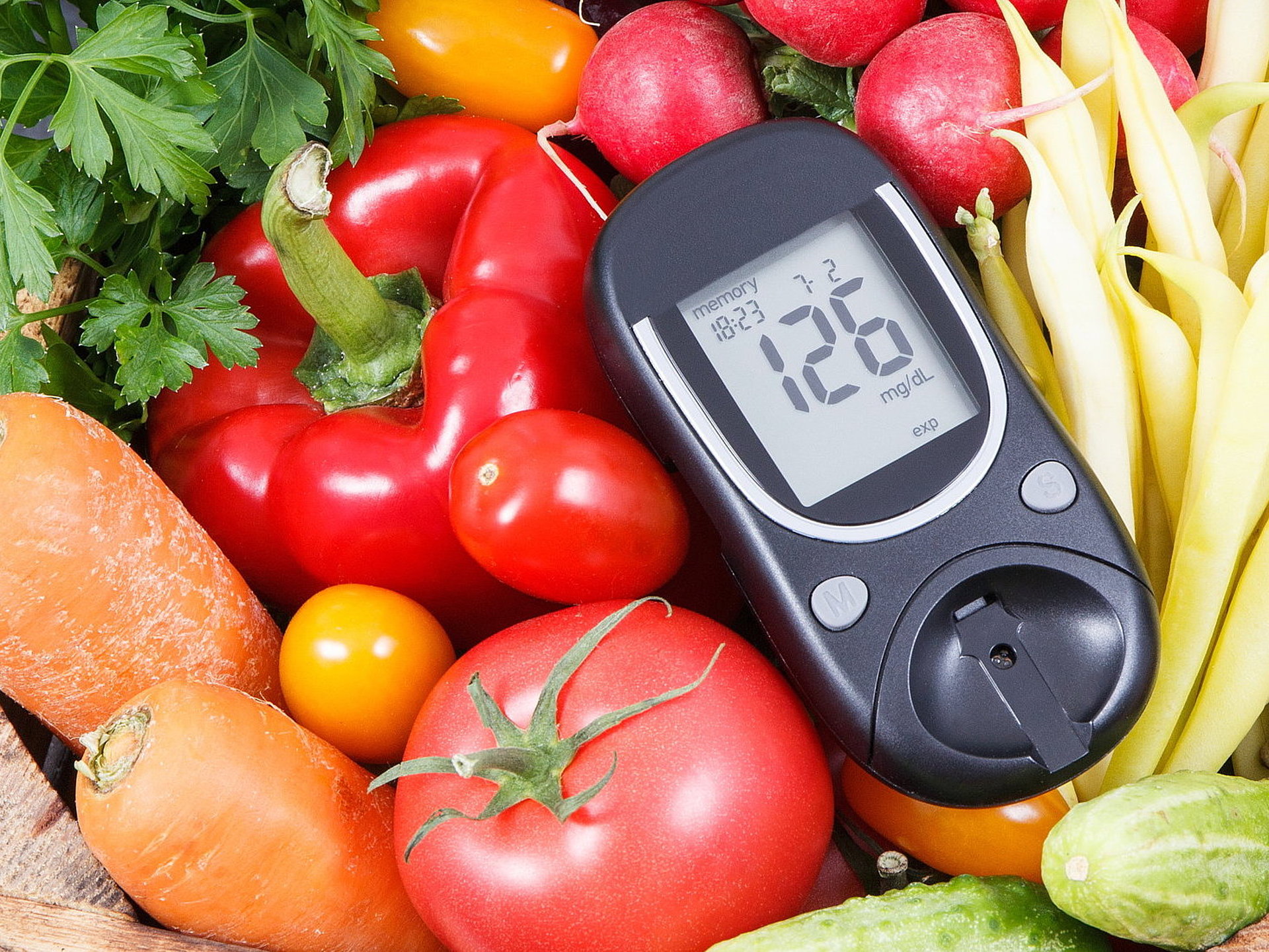 Glucometer with fresh vegetables as source minerals and vitamins. Diabetes, healthy lifestyles and dieting Blutzuckermessgerät in einem Korb mit Gemüse liegend